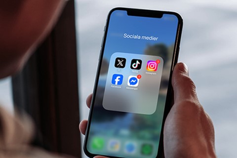 Bild på telefon med sociala medier ikoner 