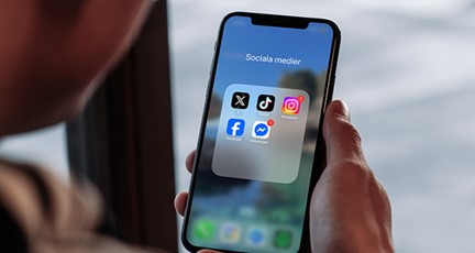 Bild på telefon med sociala medier ikoner 