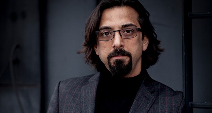 Man i långt hår, glasögon och skägg