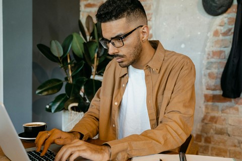 Man arbetar koncentrerat vid laptop