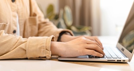inzoomning på händer på en laptops tangentbord 
