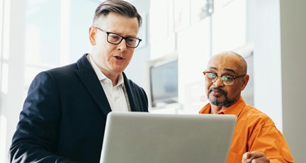 Två män står framför laptop