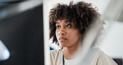 Kvinna sitter framför datorskärm