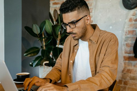 man arbetar koncentrerat vid laptop