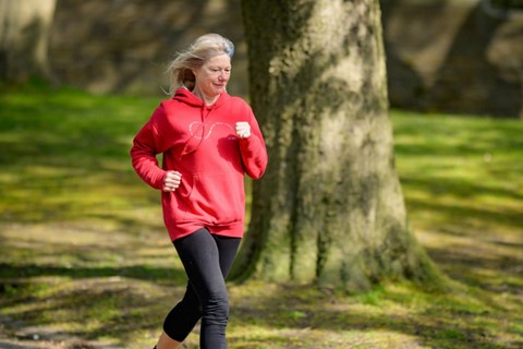 Kvinna i röd tröja joggar utomhus