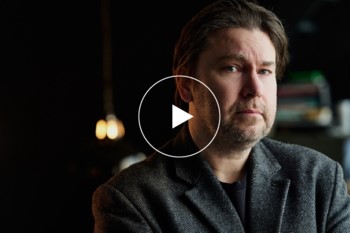 Man i m&ouml;rk kostym tittar mot kameran