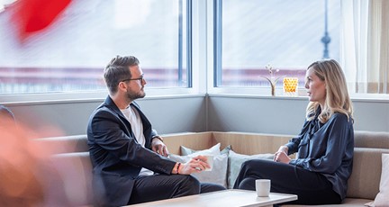 Man och kvinna sitter i en soffa och samtalar