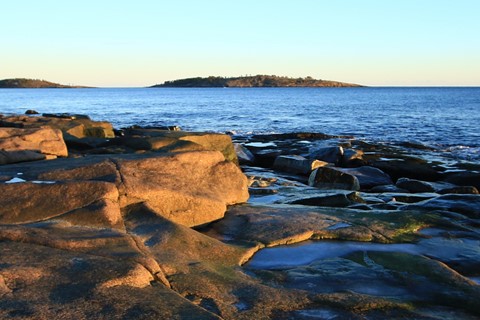 Kustlandskap med klippor vid havet i solnedgång nära ö – naturfoto från Sverige.