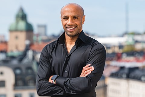 Aaron Kroon Leende man med utsikt över takåsar bakom sig