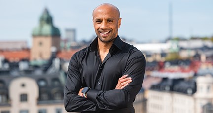 Leende man med utsikt över takåsar bakom sig