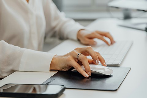 Närbild på skrivbord med datormus, tangentbord och smartphone